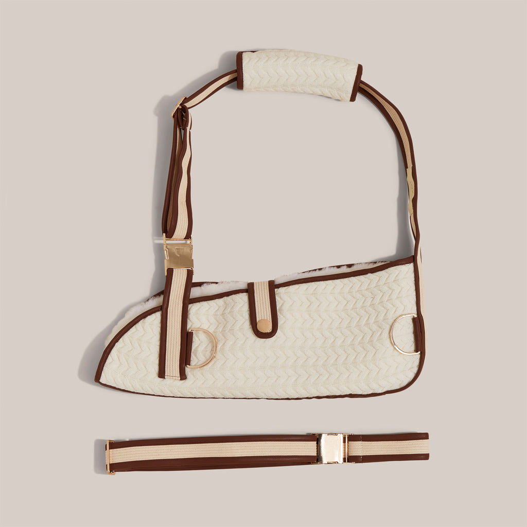 Still life image of cashmere wool knit arm sling with a soft shearling lining.