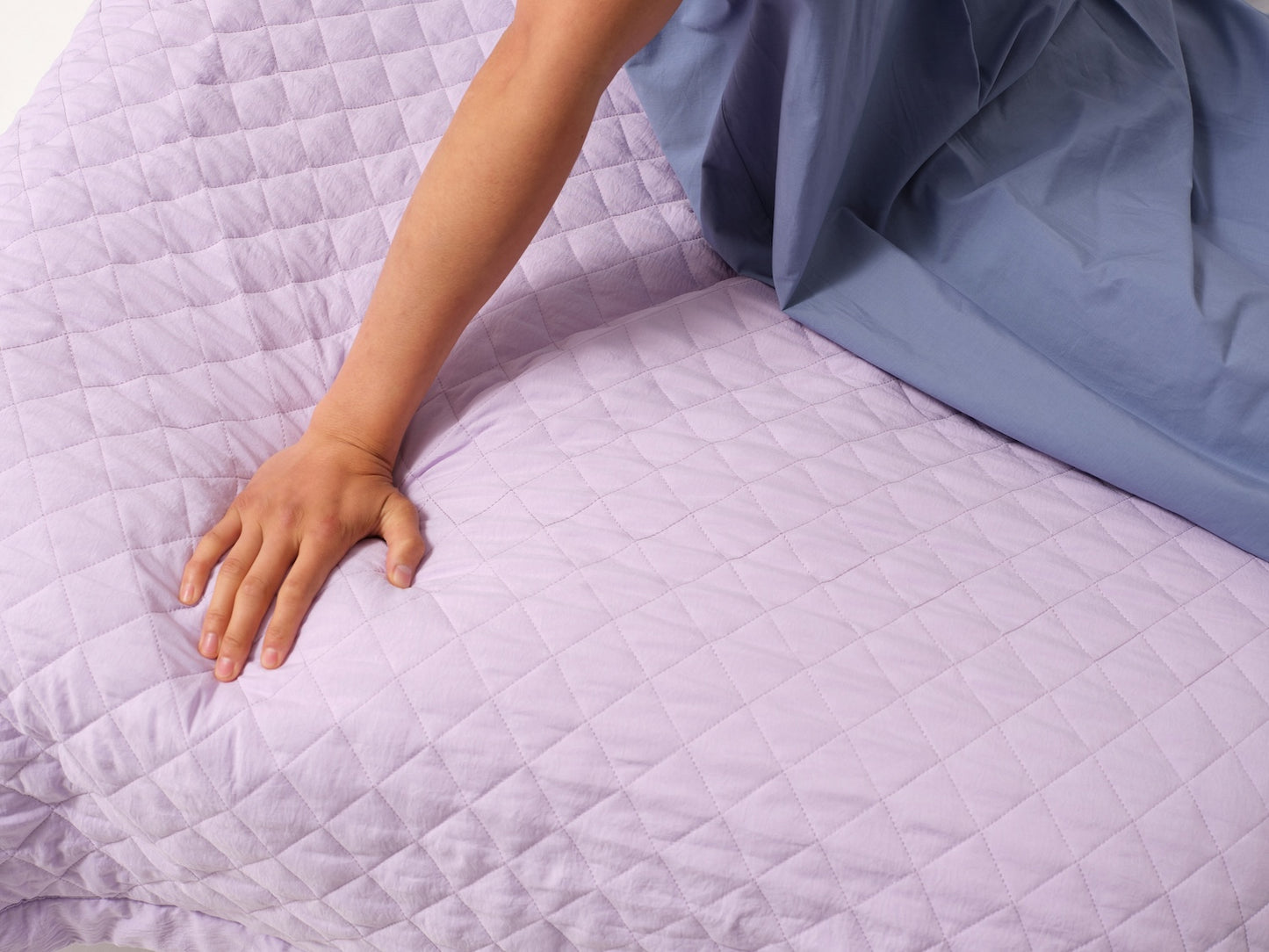 Quilted blanket on bed with model in patient gown