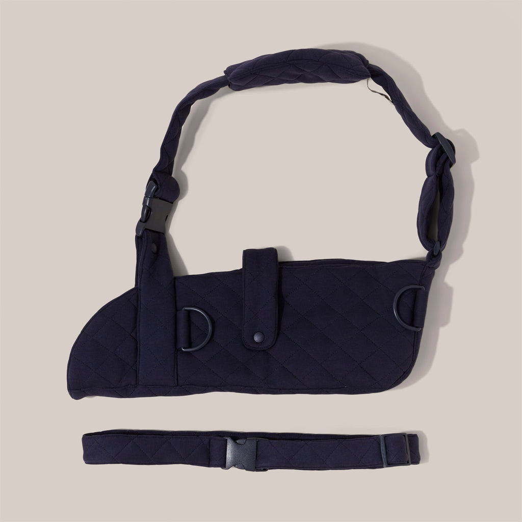 Navy jersey arm sling with a wide shoulder strap and  recycled plastic hardware against a plain background.