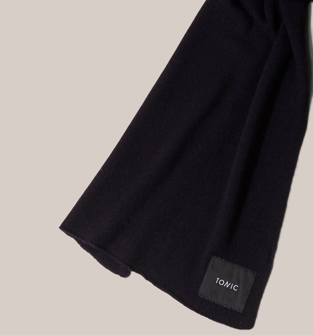 Zoomed in detail of Wide navy  cashmere scarf arranged as if worn and showing label detail.