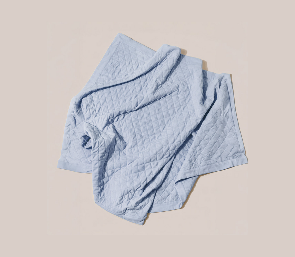 Light blue quilted blanke on a white background 