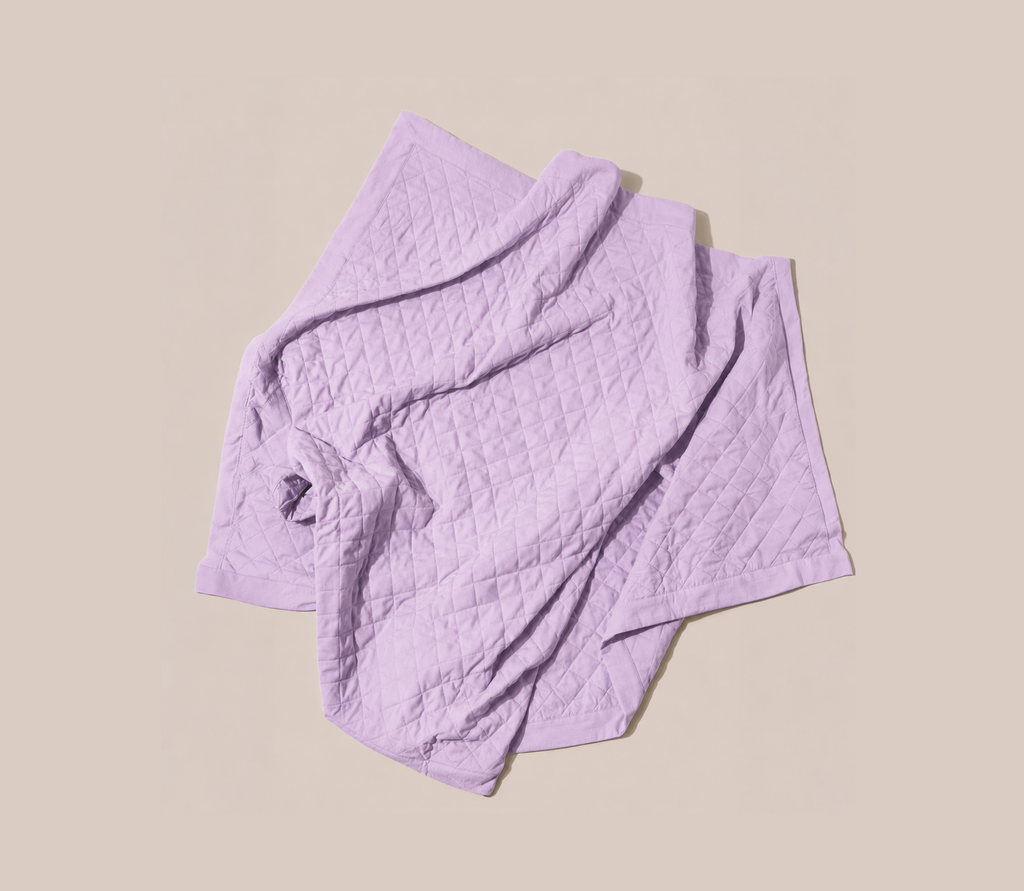 Quilted lilac blanket on a light background